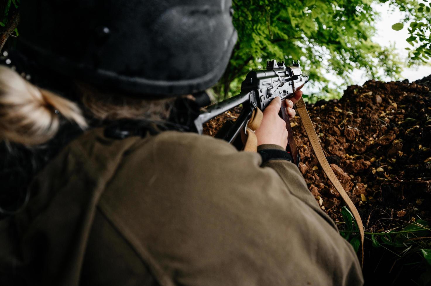 soldat dans une tranchée sur la ligne de front de la guerre ukraino-russe, défense des frontières ukrainiennes contre les orcs. photo
