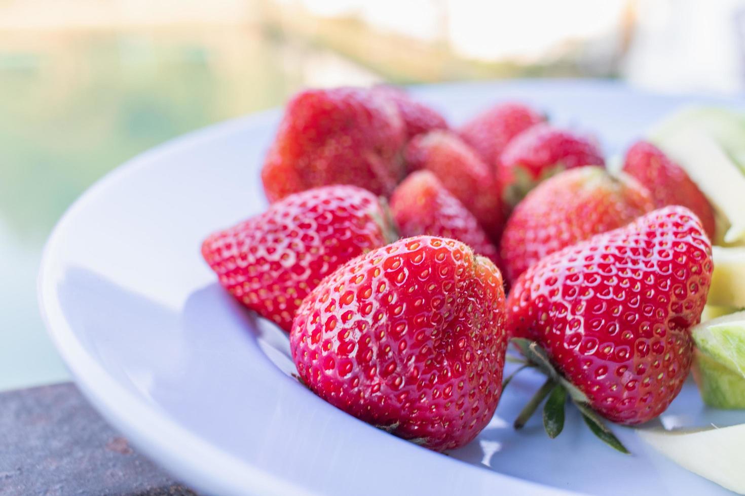 des fraises rouges juteuses sont associées à des mangues crues vertes croquantes et sucrées dans une assiette que les clients peuvent choisir après le dernier repas, et les deux fruits sont des moments de saison qui peuvent être faciles à manger en thaïlande. photo