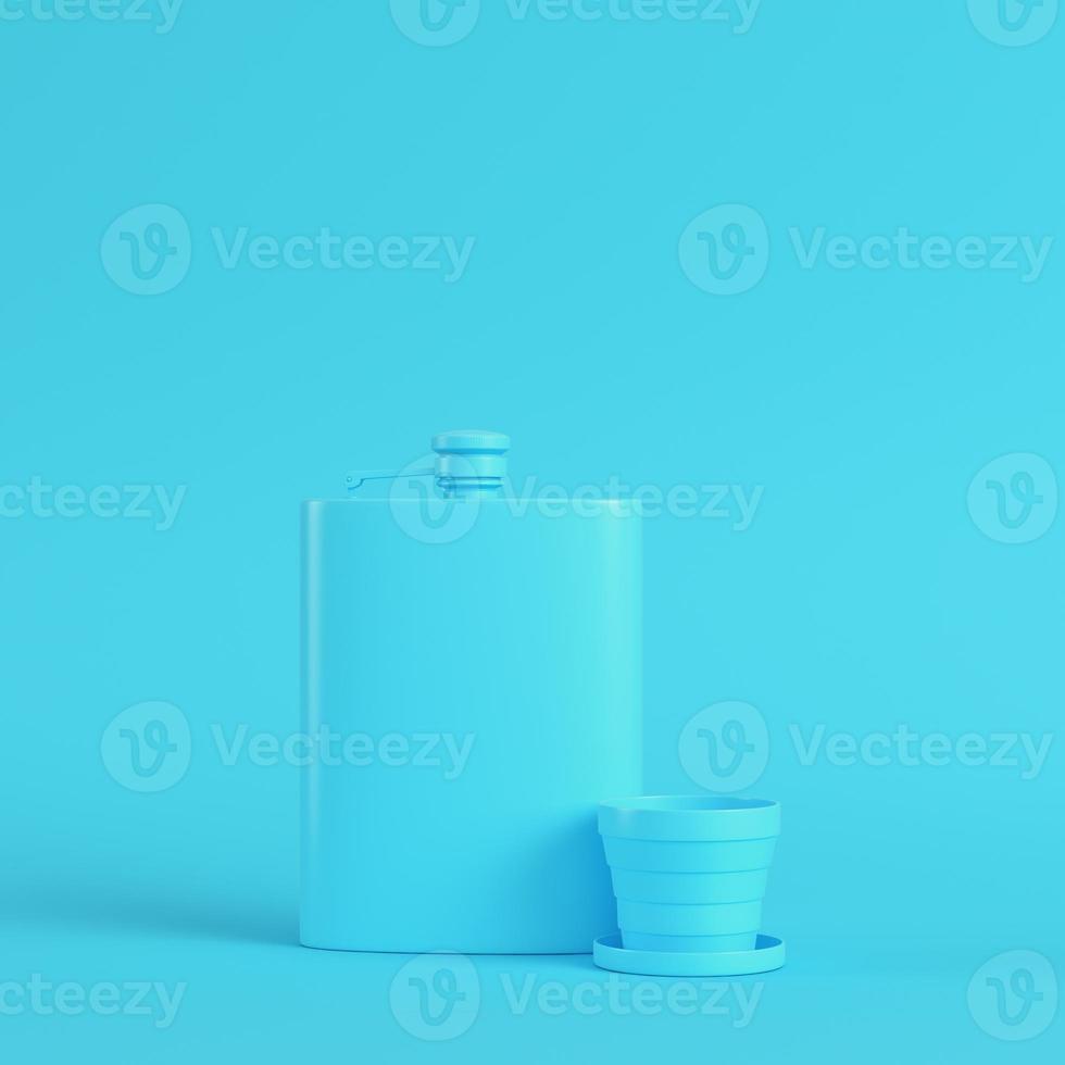 flasque avec tasse sur fond bleu vif dans des tons pastel. notion de minimalisme photo