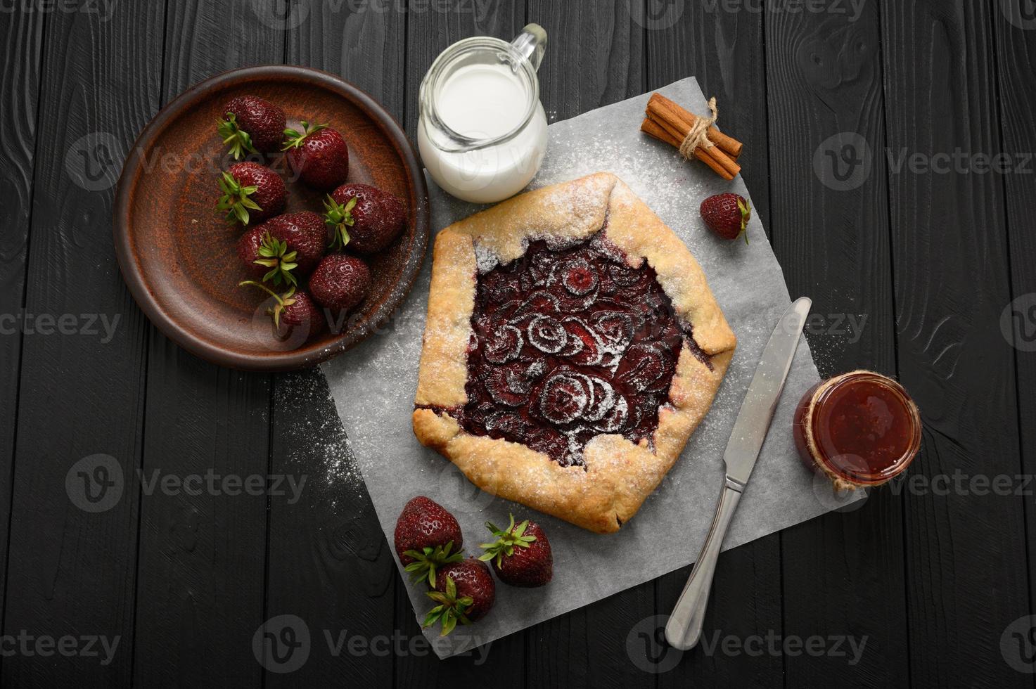 galette aux fraises sur fond de bois foncé. fait maison photo