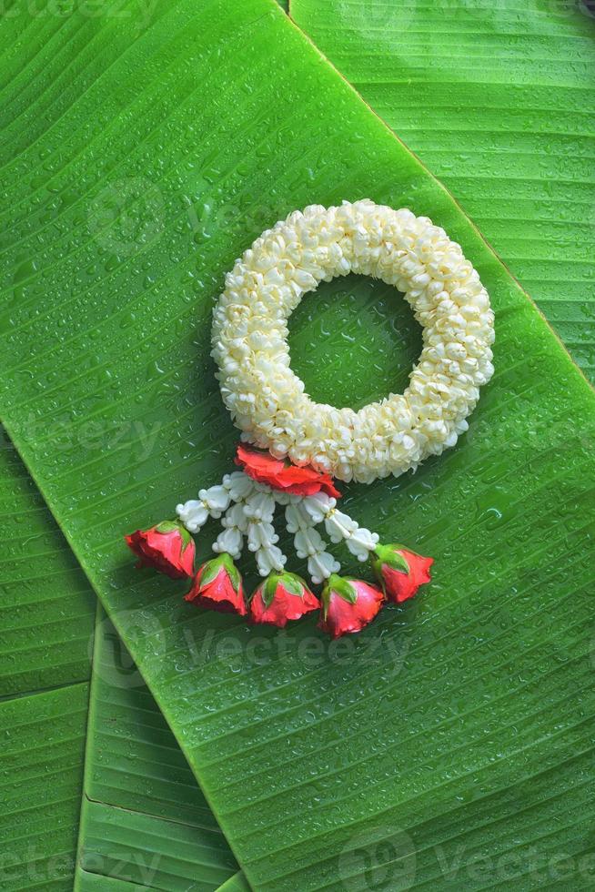 guirlande de jasmin traditionnel thaïlandais.symbole de la fête des mères en thaïlande sur une feuille de bananier photo