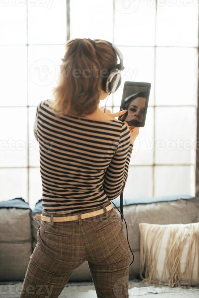 jeune femme écoutant de la musique dans le loft. vue arrière photo