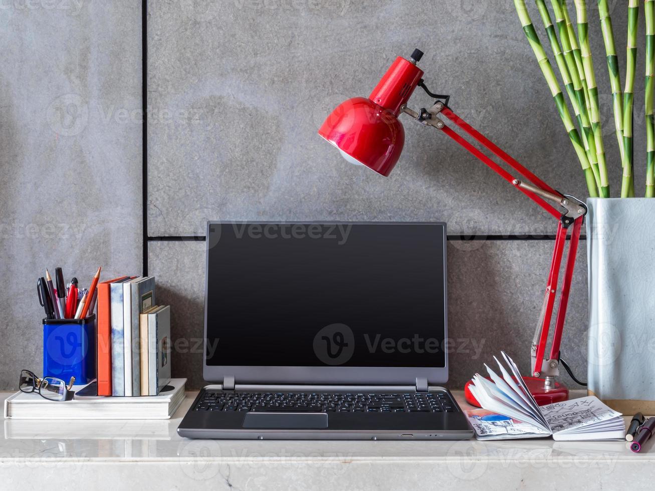 bureau moderne avec ordinateur portable, lampe et vase de fleurs