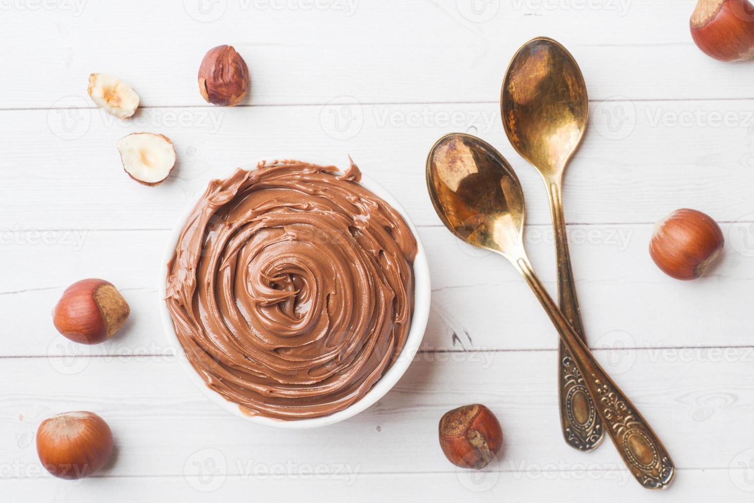 chocolat aux noix de nougat dans une assiette sur fond blanc avec des noisettes. notion de petit-déjeuner. photo