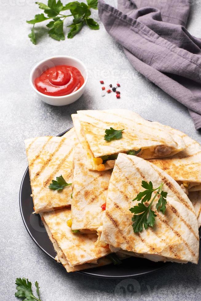 tranches triangulaires d'une quesadilla mexicaine avec la sauce. le plat traditionnel du mexique est les tortillas farcies de viande et de légumes. espace de copie. photo