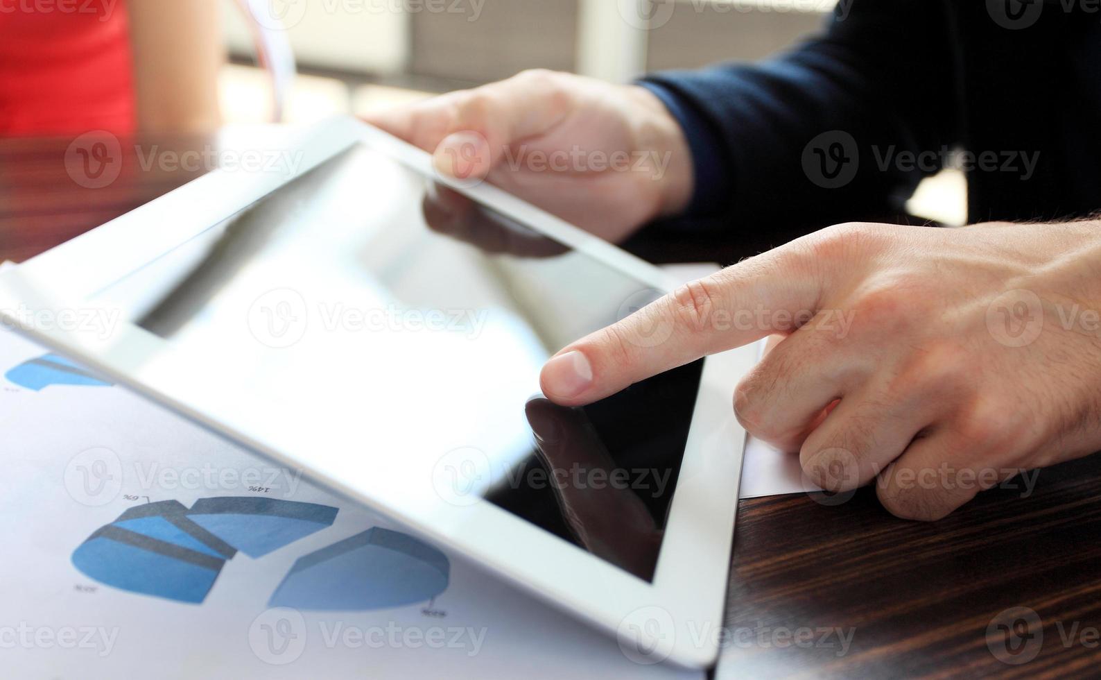 toucher la main sur une tablette numérique moderne sur le lieu de travail photo