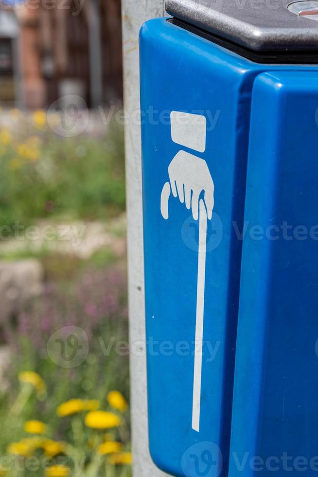 bac bleu à l'extérieur dans une rue avec la main avec la canne photo