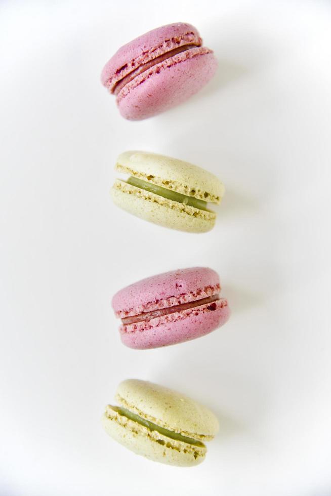 macarons tombant sur fond blanc. desserts français sucrés. macarons sur une assiette blanche. macarons sur la table l'après-midi. photo