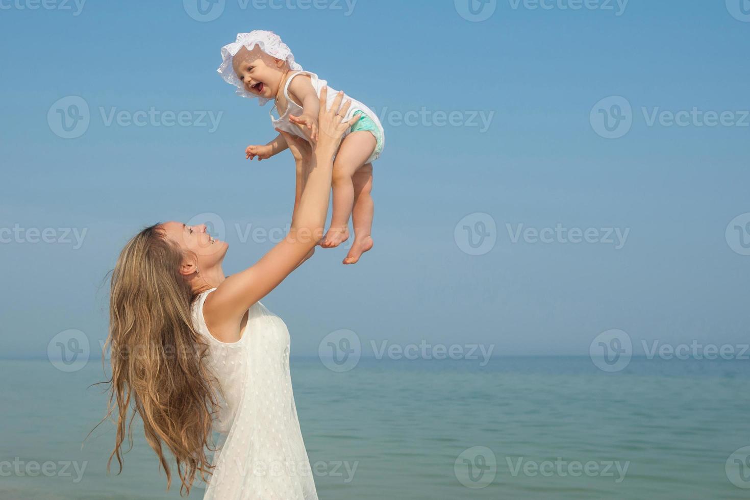 heureuse belle mère et fille profitant du temps à la plage photo