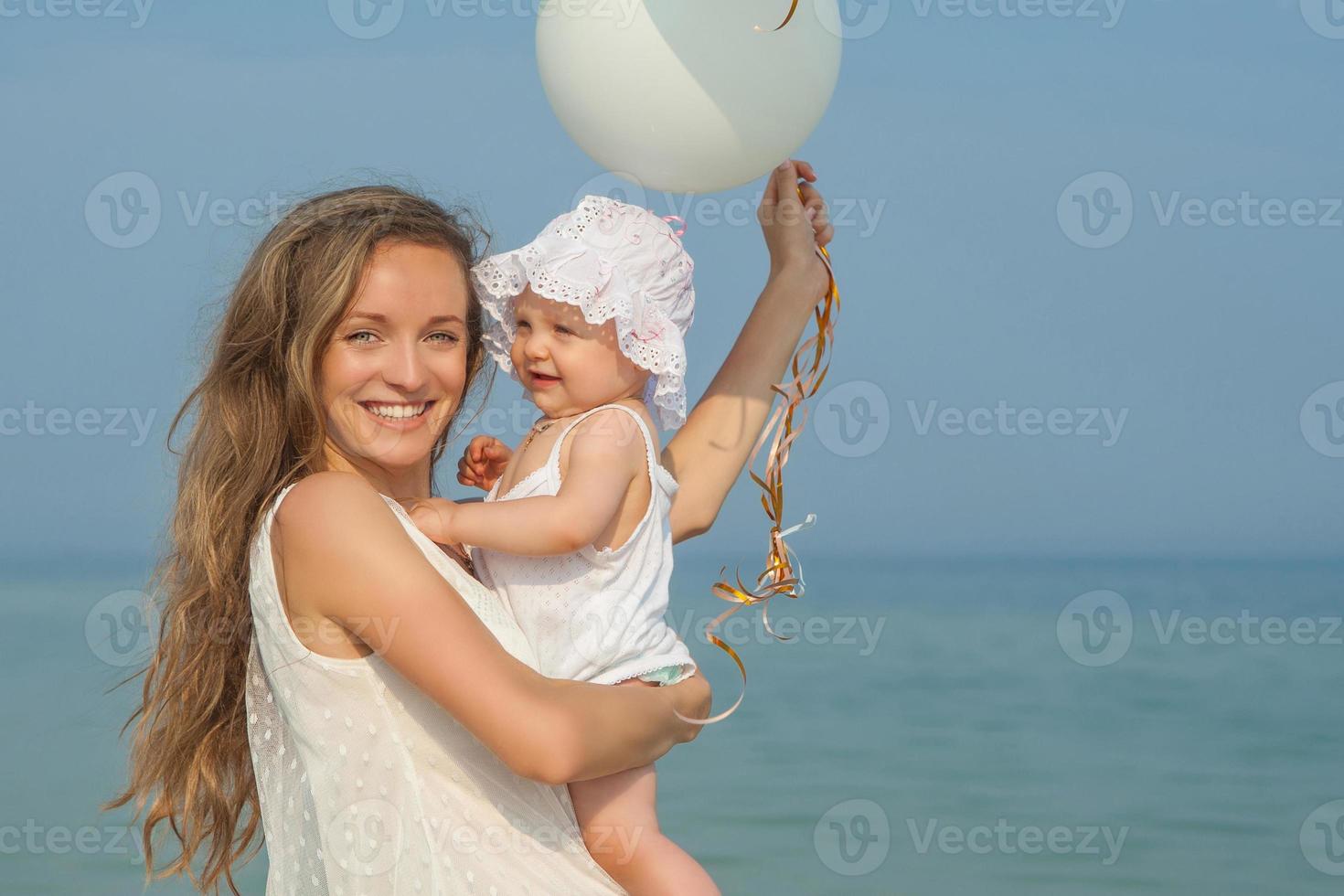 heureuse belle mère et fille profitant du temps à la plage photo