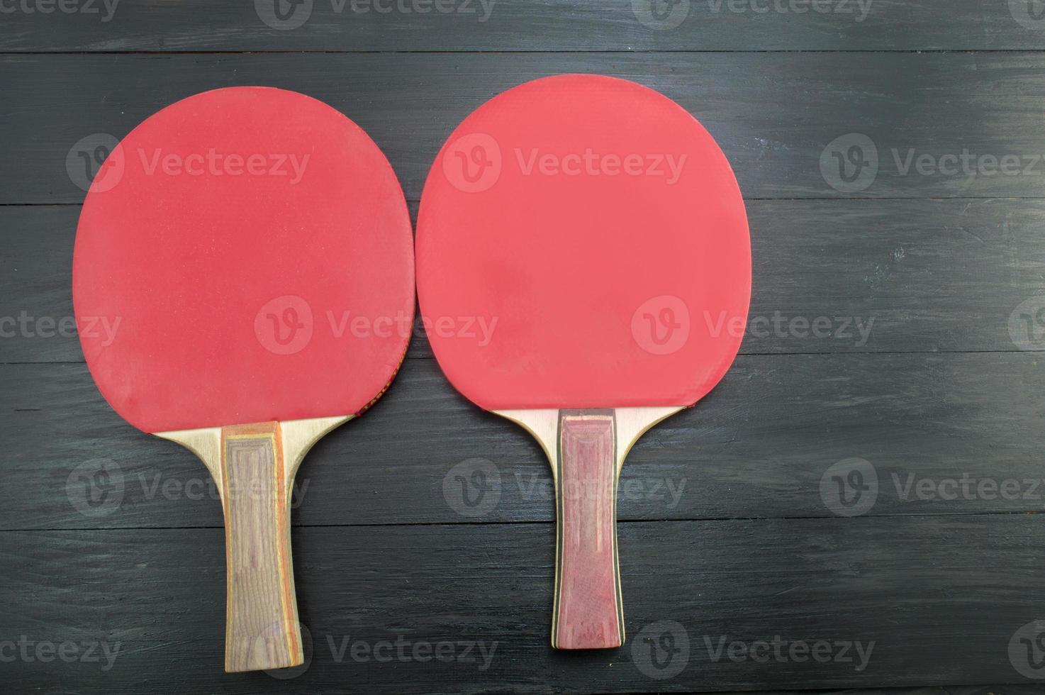 deux raquettes de tennis de table rouge sur fond sombre photo
