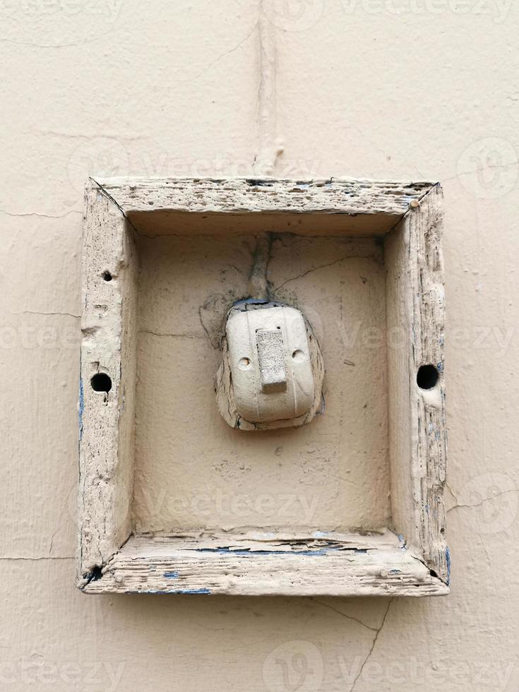 ancien interrupteur d'éclairage sur un mur de ciment. lumière naturelle. décentré photo