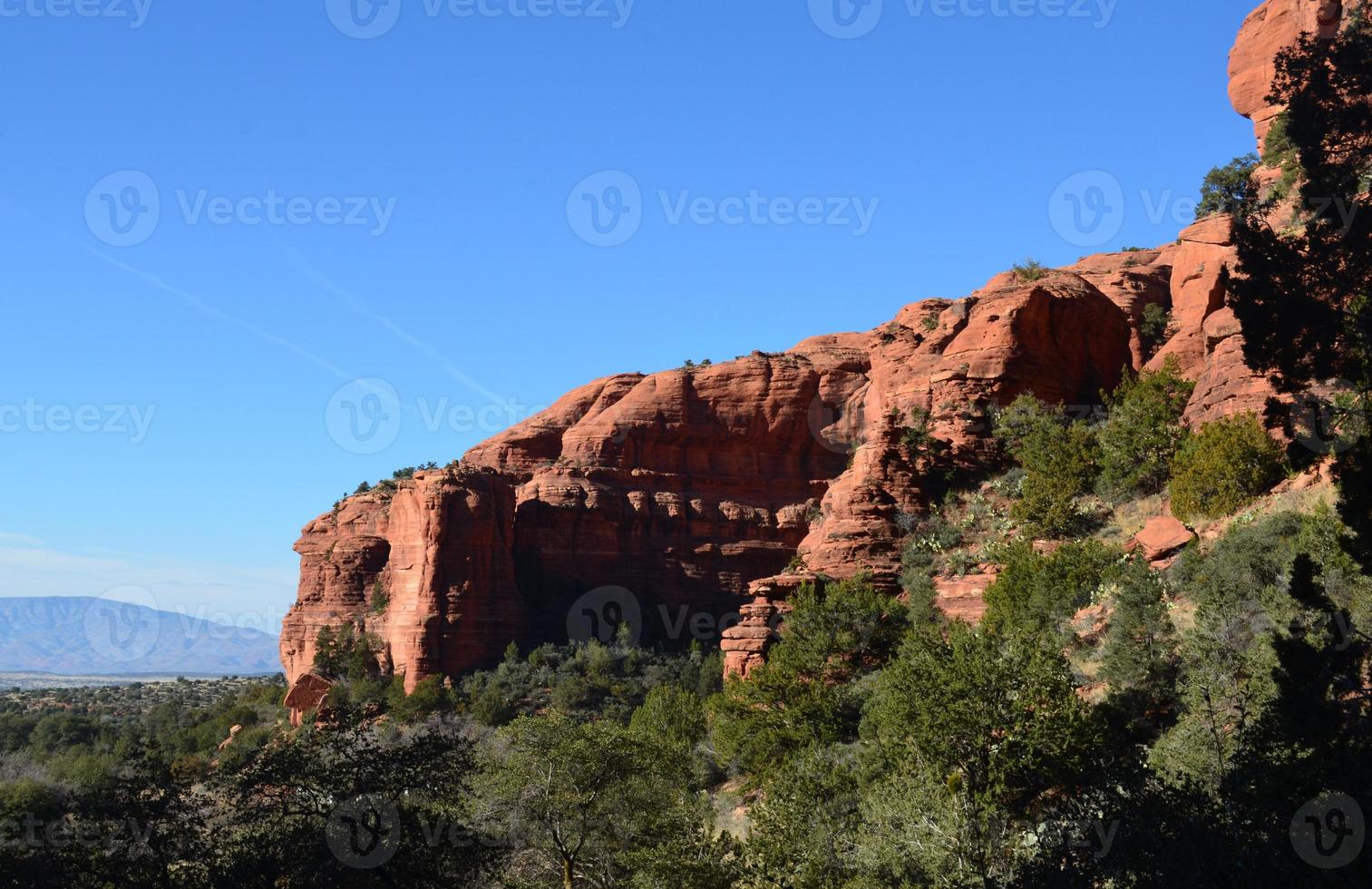 ciel bleu sans nuages au-dessus de la butte de roche rouge photo