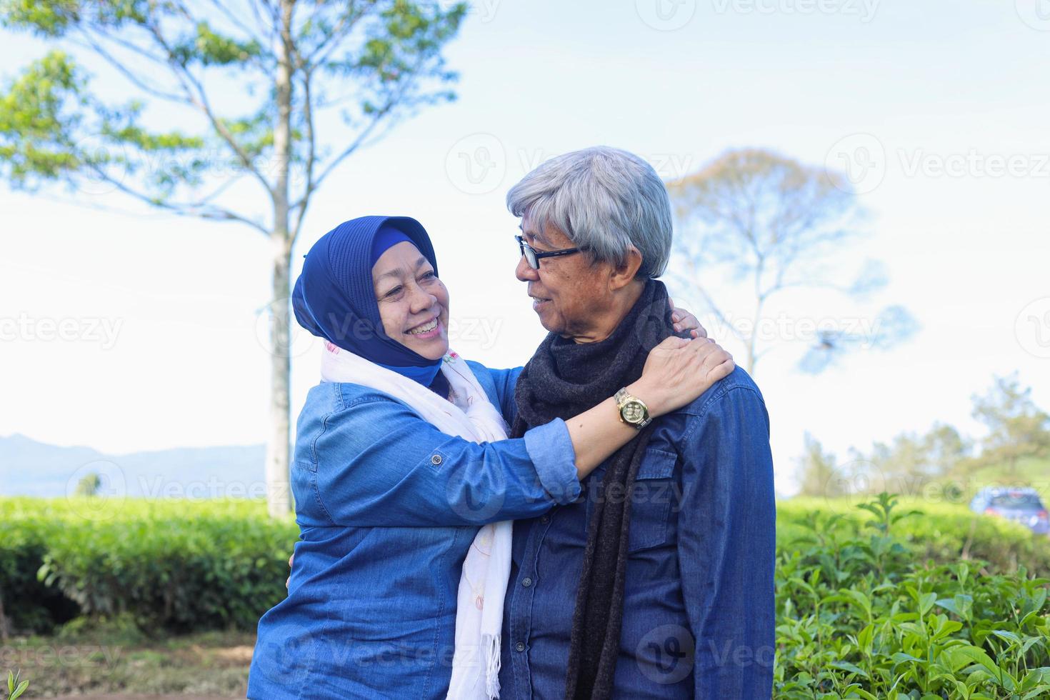 heureux couple de personnes âgées riant les uns les autres à la plantation de thé. photo