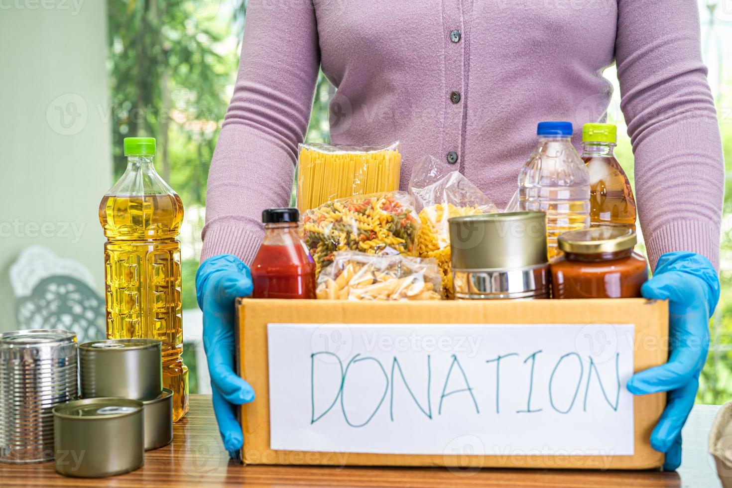 denrées alimentaires pour le don, le stockage et la livraison. divers aliments, pâtes, huile de cuisson et aliments en conserve dans une boîte en carton. photo