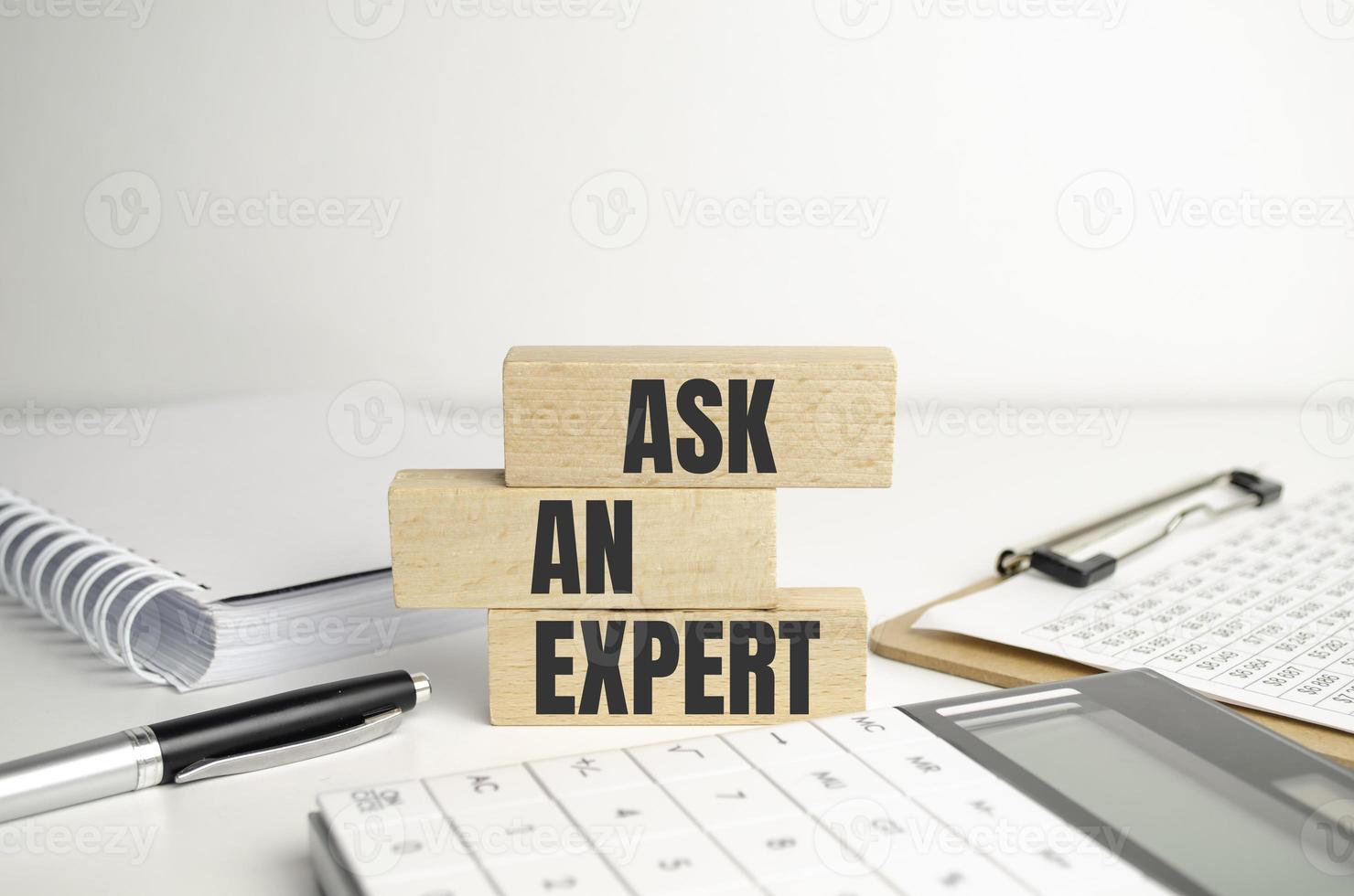 demander à un expert des mots sur des blocs de bois. consulter un professionnel, un maître ou un consultant pour un concept d'entreprise de solution et de conseil. photo