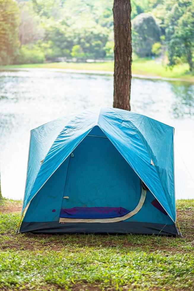 camping sous la forêt, tente bleue près du lac. concept de voyage, de voyage et de vacances en plein air photo