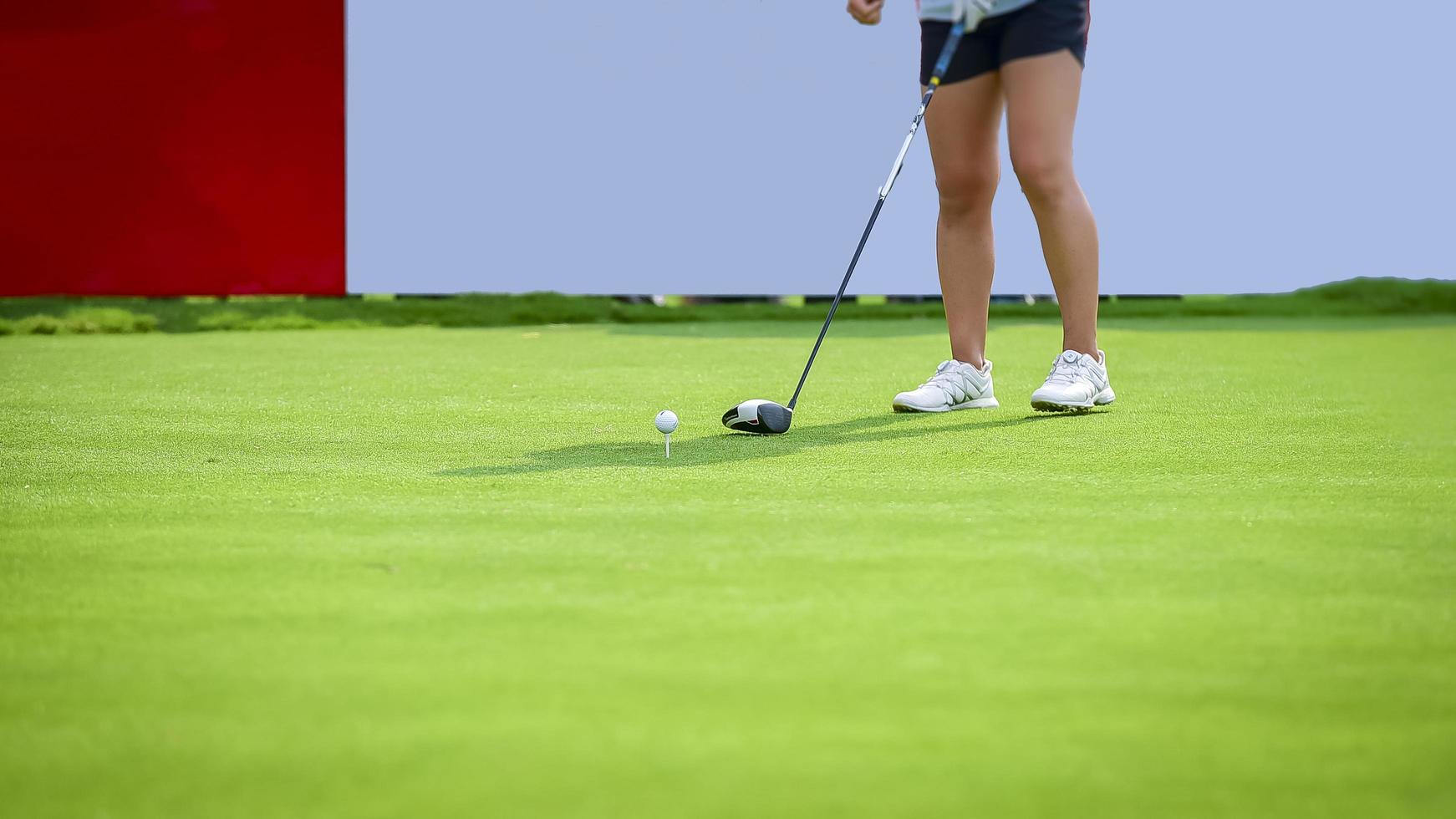 golfeur poussant la balle de golf blanche au trou sur le terrain de golf dans le jeu de compétition de golf, les rayons du soleil et l'arrière-plan flou photo