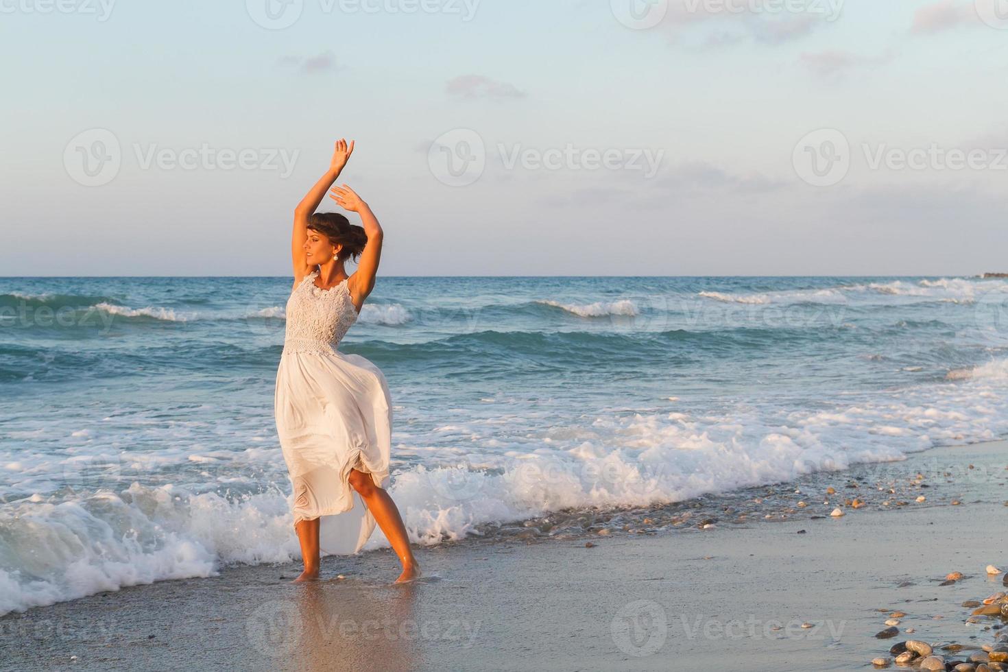 jeune femme bénéficie d'une promenade sur la plage au crépuscule. photo