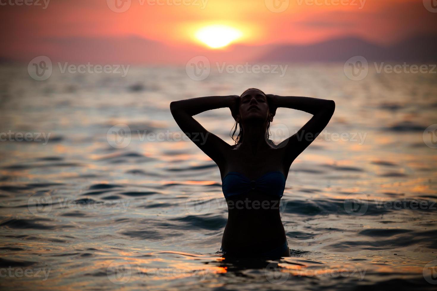 magnifique silhouette de femme fit nager dans sunset.free femme appréciant le coucher du soleil. photo