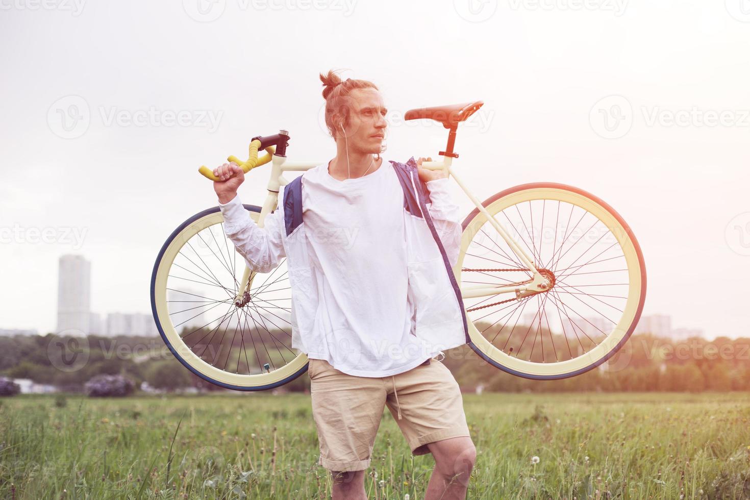 homme en t-shirt blanc debout avec vélo photo