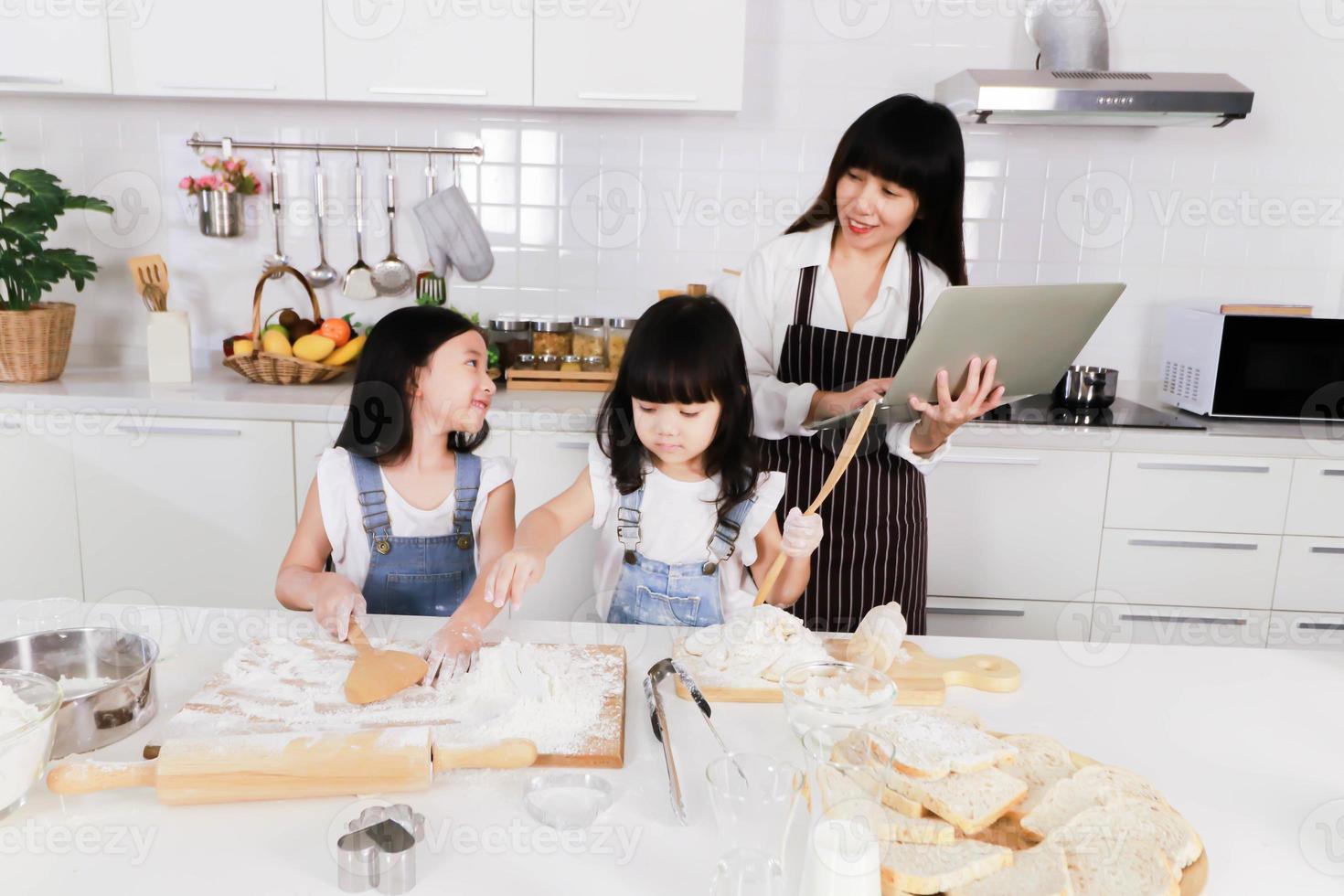 petite soeur à la recherche d'une mère et d'une petite fille faire une pâtisserie photo