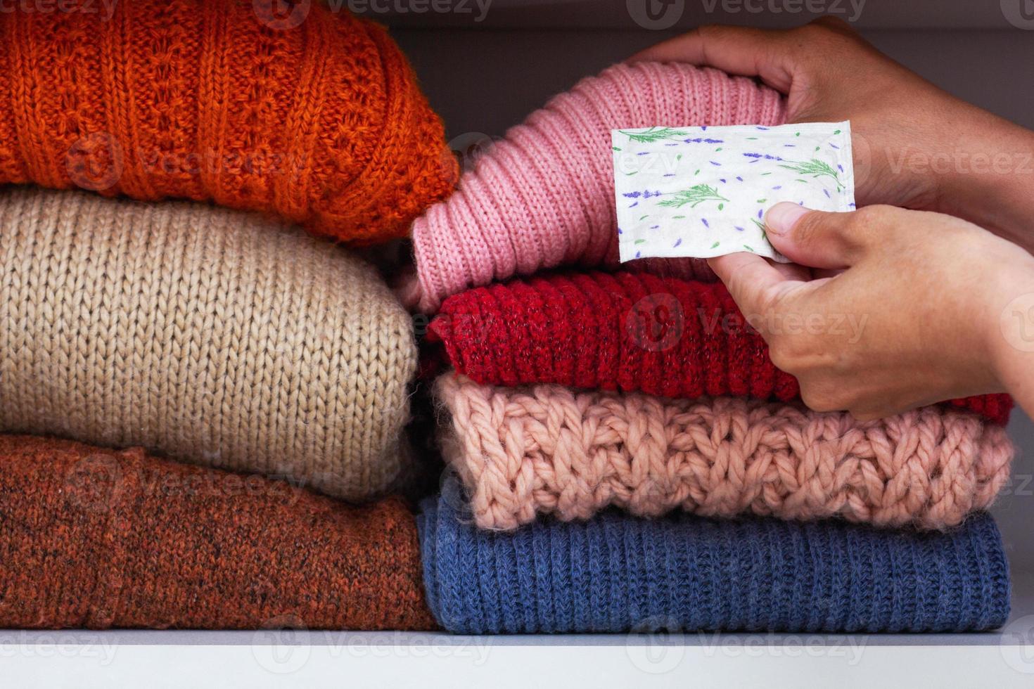 mains mettant un sachet de lavande séchée dans une armoire photo