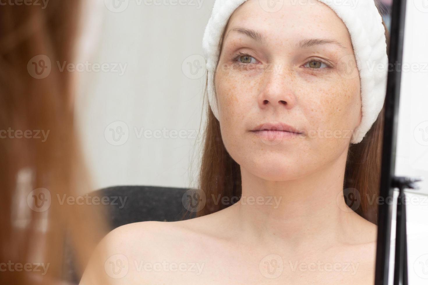 femme avec un bandeau sur la tête regardant dans un miroir photo