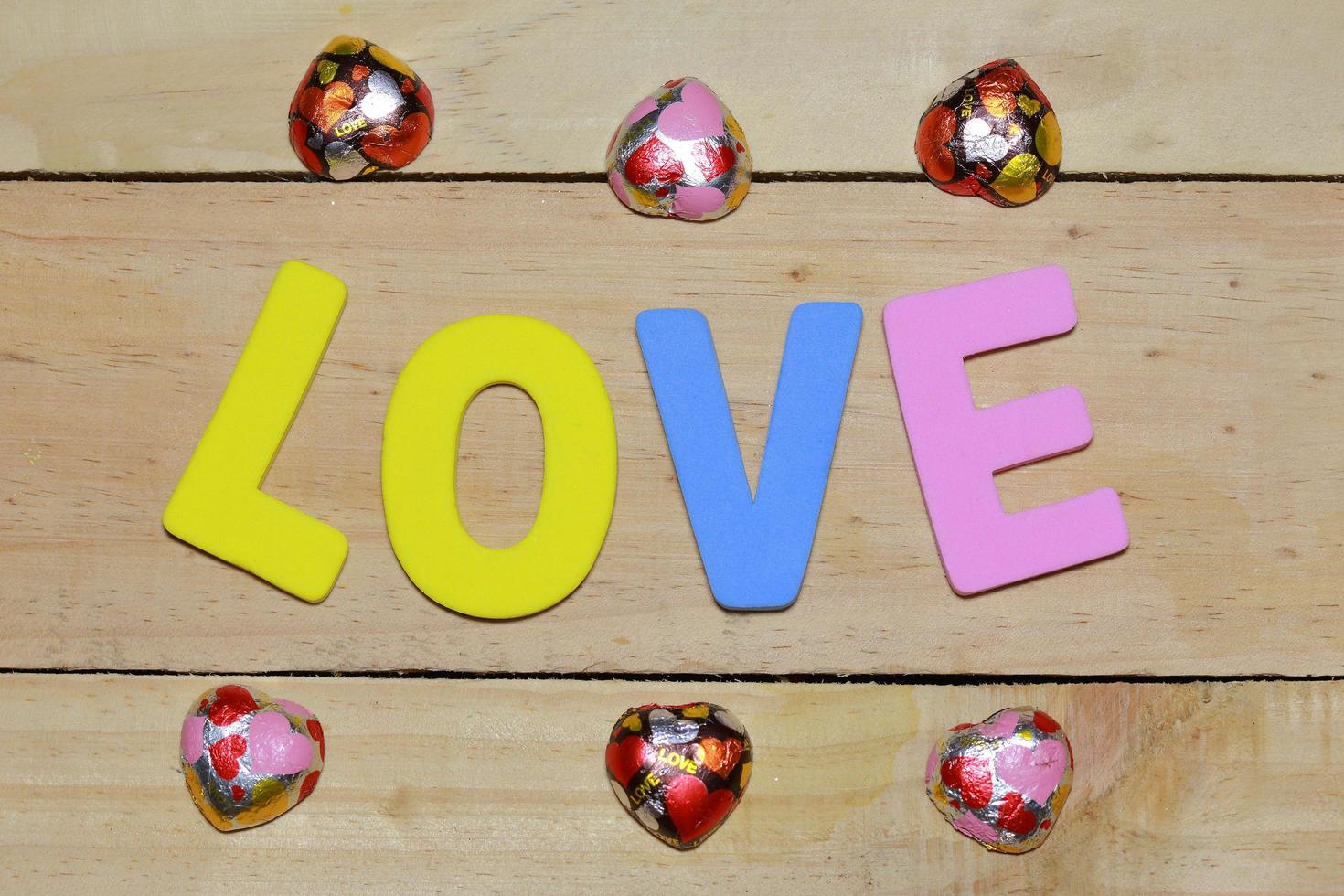 lettres d'amour et coeur en chocolat sur le parquet. fond saint valentin avec des coeurs. concept de la Saint-Valentin. espace pour le texte. photo