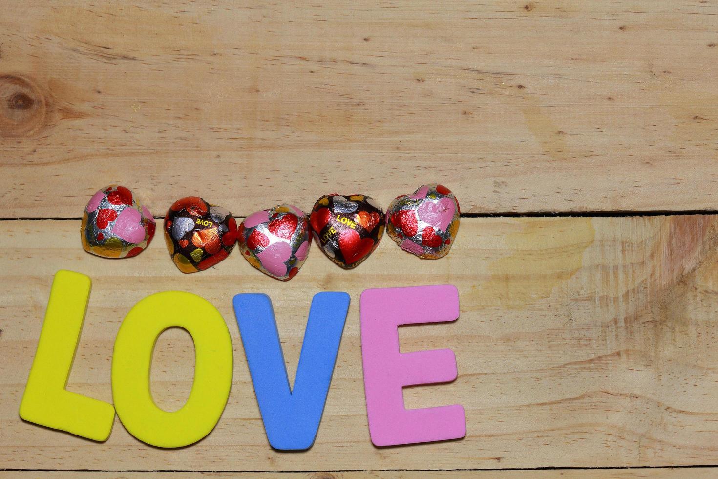 lettres d'amour et coeur en chocolat sur le parquet. fond saint valentin avec des coeurs. concept de la Saint-Valentin. espace pour le texte. photo