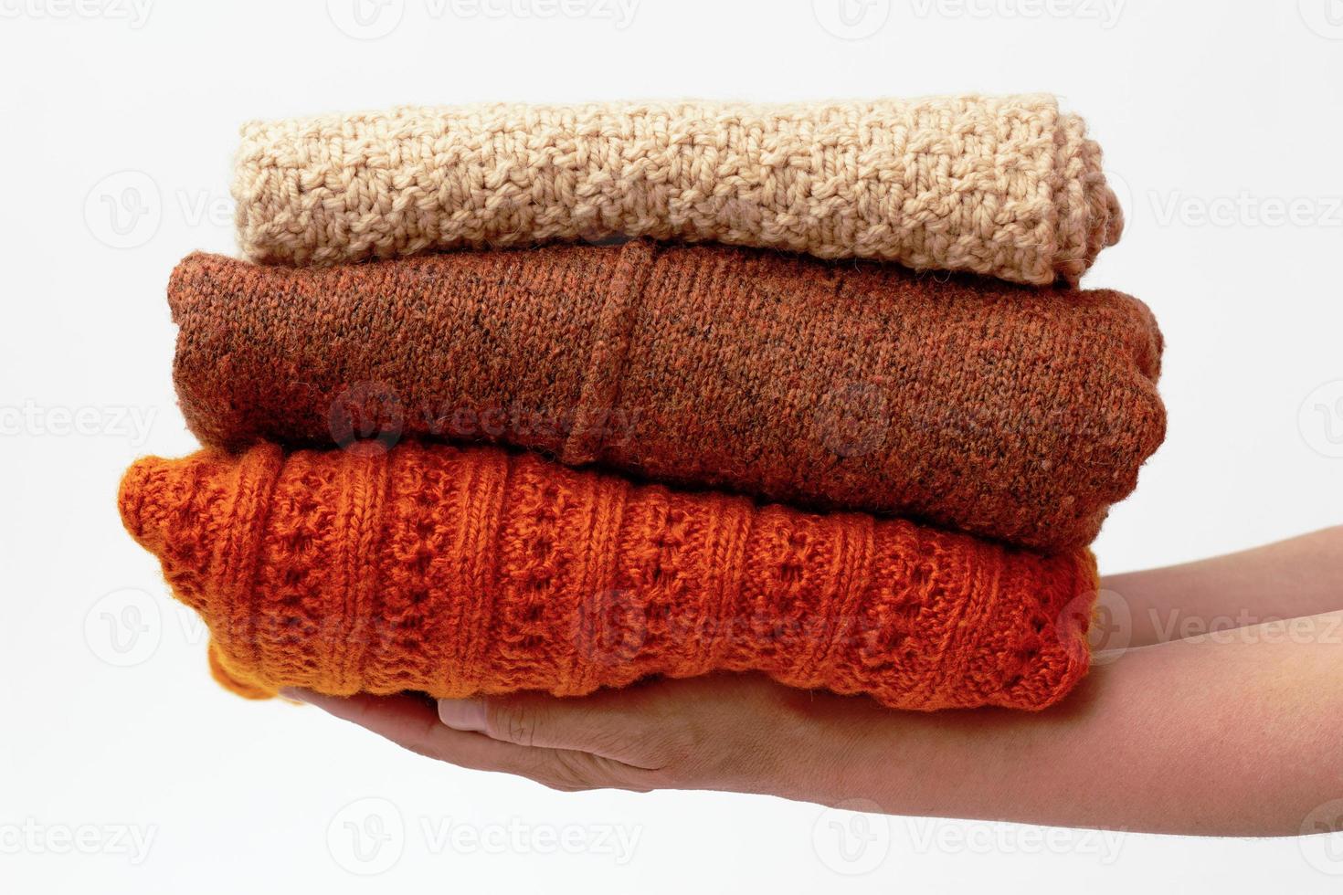 mains tenant une pile avec des vêtements en laine photo