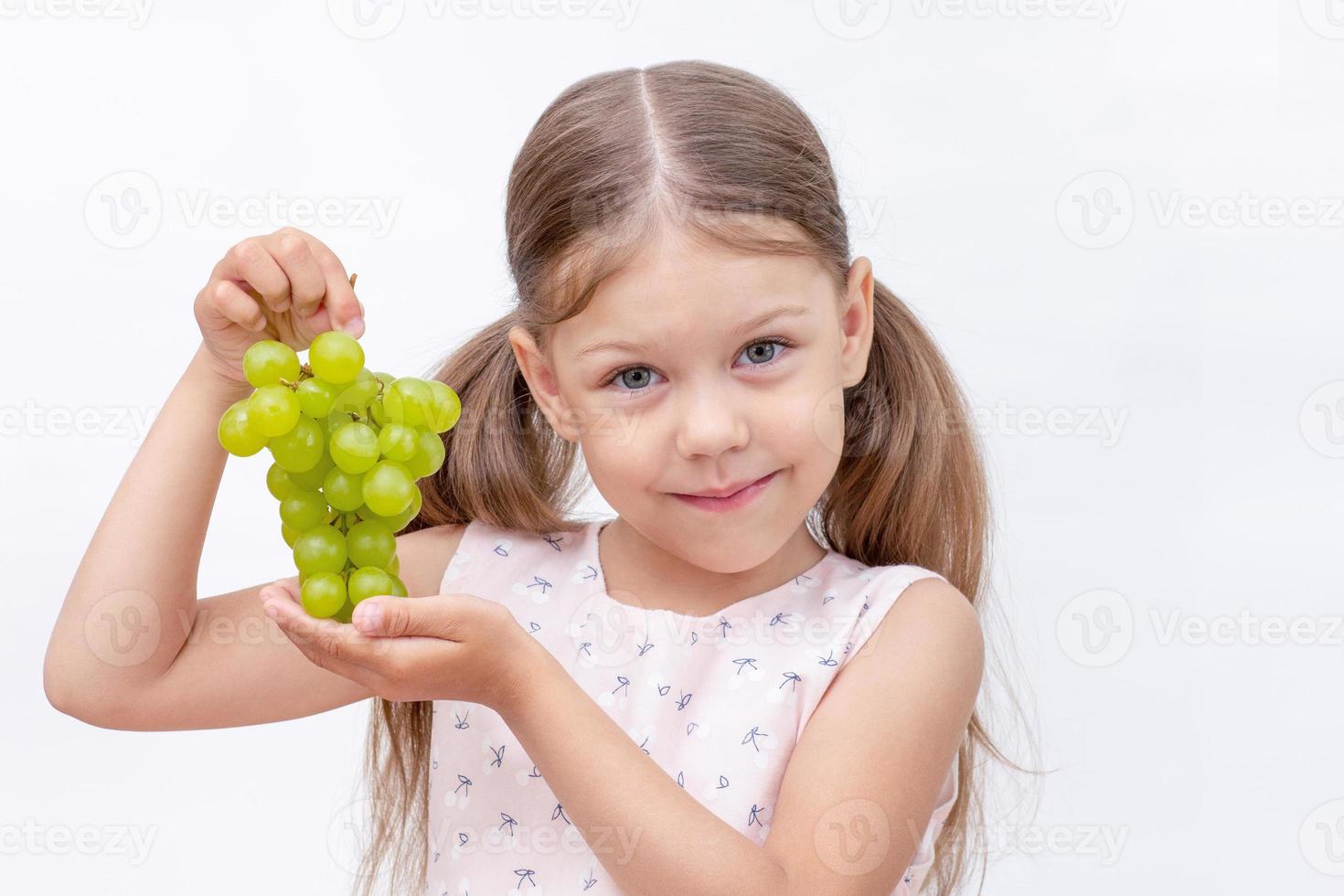 enfant tenant une grappe de raisin photo