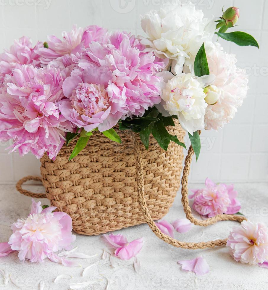 sac en osier avec des fleurs de pivoine photo