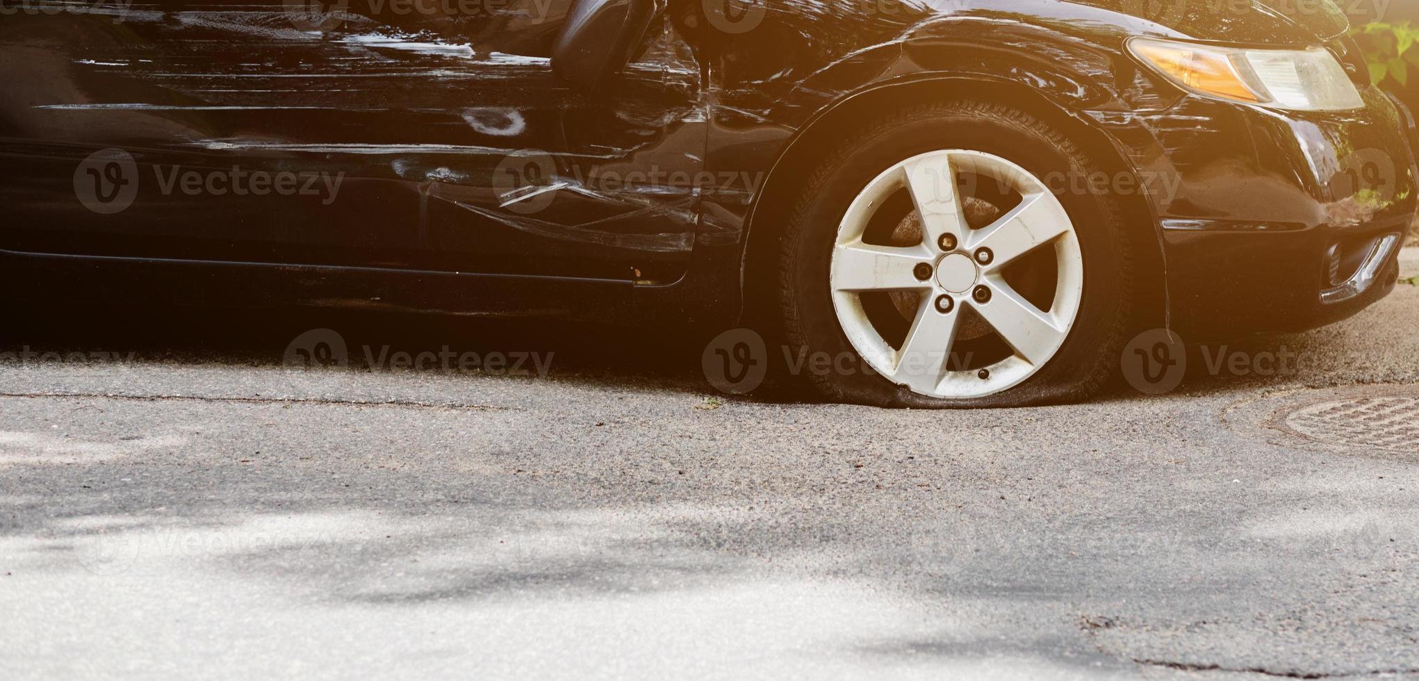 gros plan de pneu de voiture crevé. abattu dans la roue par la police alors  qu'il poursuivait un contrevenant. trou de balle dans un gros plan de pneu  de roue. pneus avec