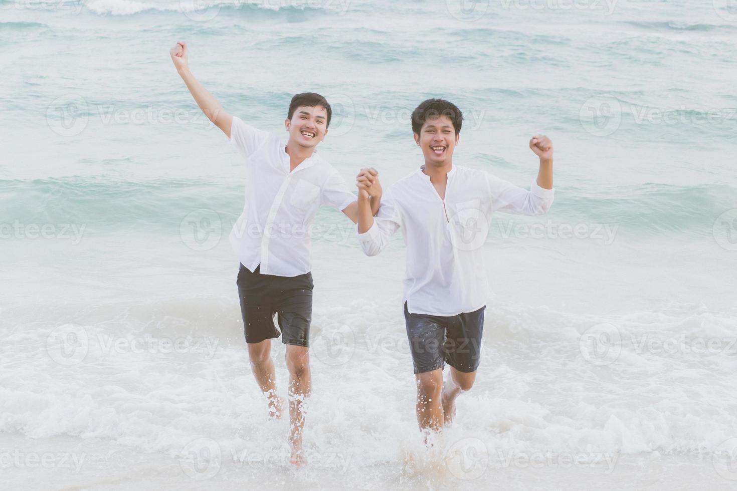 portrait homosexuel jeune couple asiatique courant avec gai ensemble sur la plage en été, asie gay faisant du tourisme pour les loisirs et se détendre avec bonheur en vacances en mer, concept juridique lgbt. photo