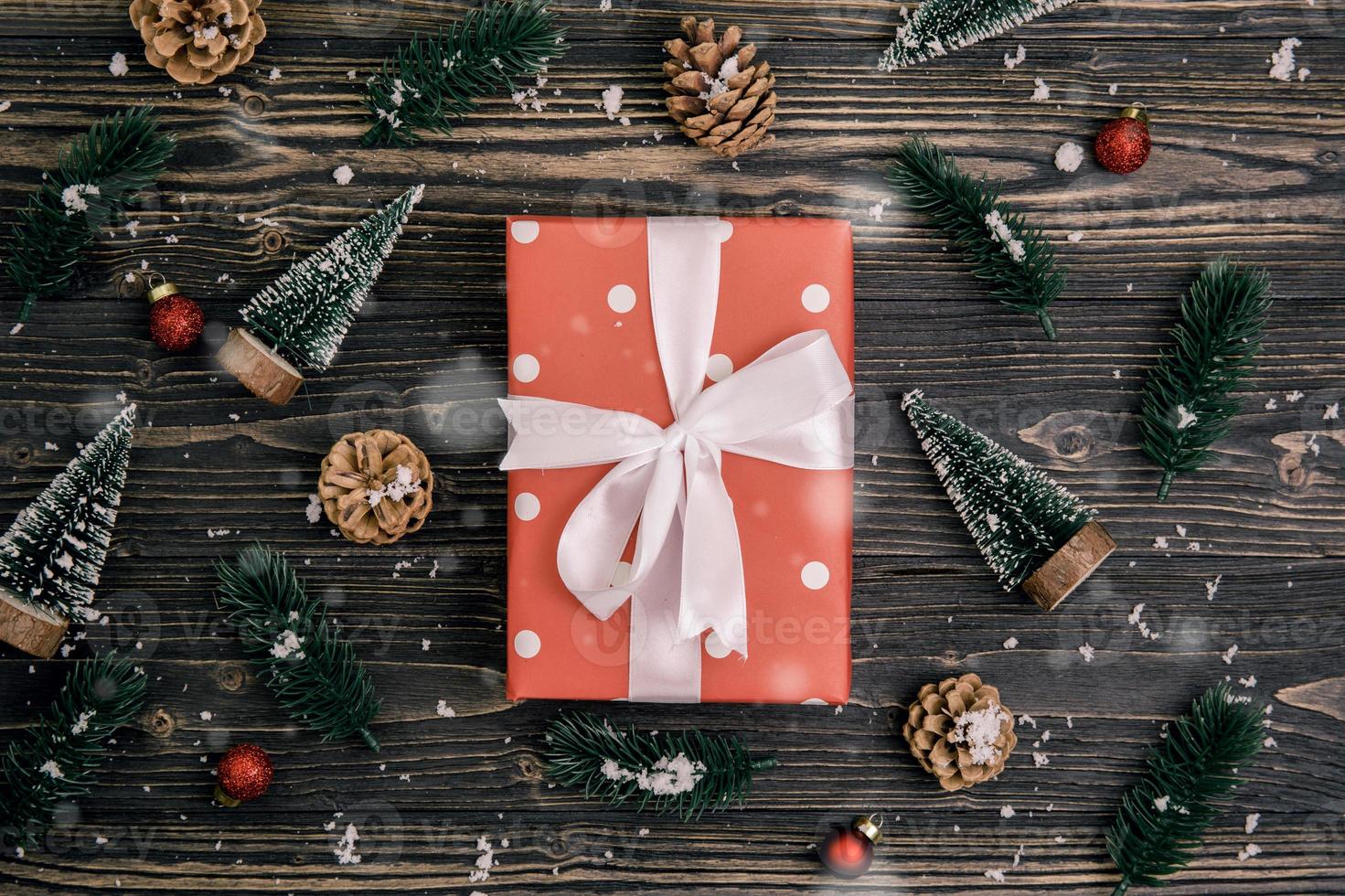 composition de vacances de noël avec boîte-cadeau rouge et décoration d'étiquette sur fond en bois, nouvel an et noël ou anniversaire avec des cadeaux sur une table en bois en saison, vue de dessus ou à plat. photo