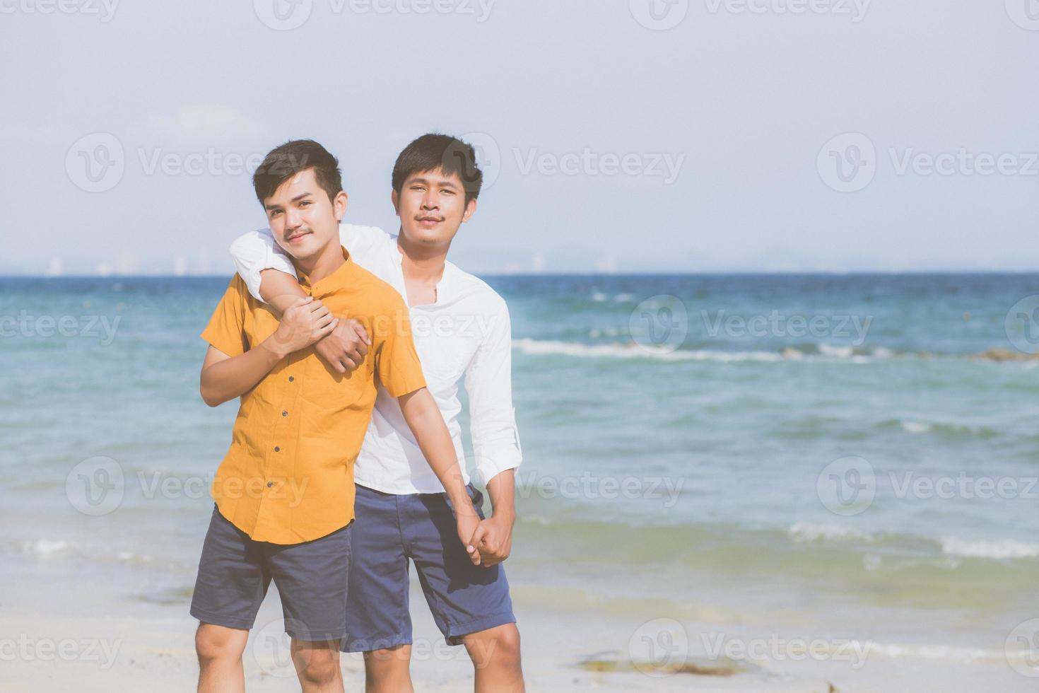 portrait homosexuel jeune couple asiatique debout câlin ensemble sur la plage en été, asie gay va tourisme pour les loisirs et se détendre avec romantique et bonheur en vacances en mer, concept lgbt. photo