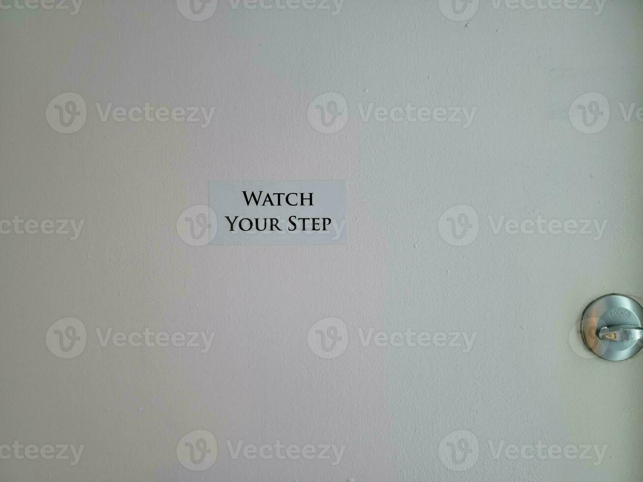 surveillez votre pas signe ou autocollant sur la porte verrouillée photo