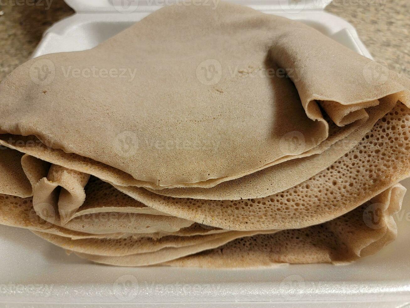 récipient en mousse avec pile de pain éthiopien appelé injera photo