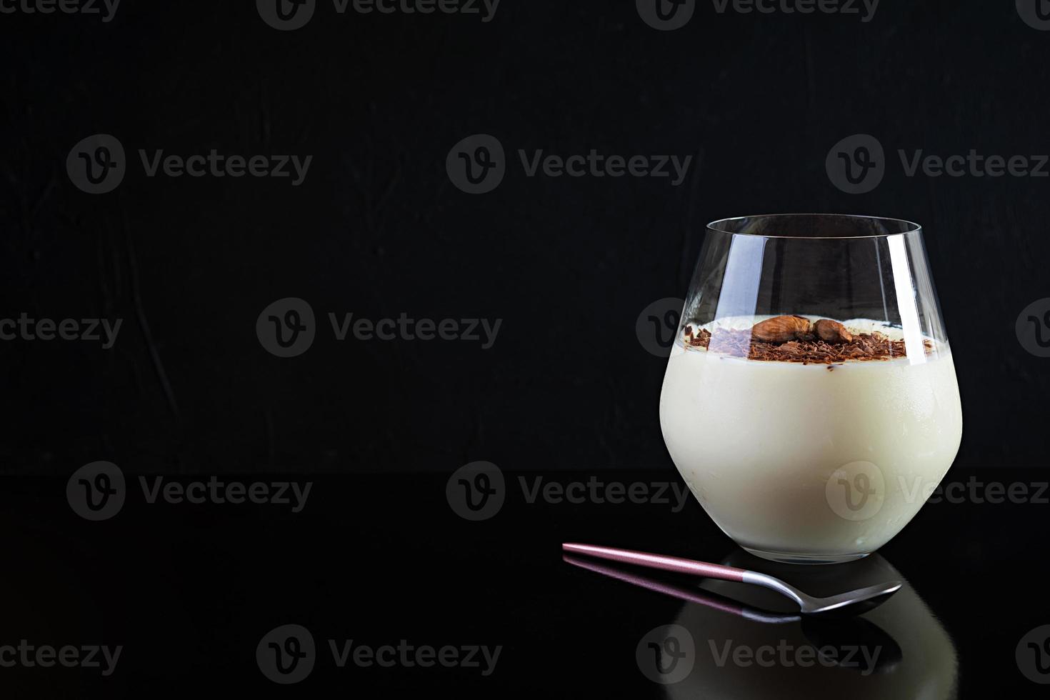 pudding au lait sucré aux amandes et pépites de chocolat isolé sur fond sombre photo
