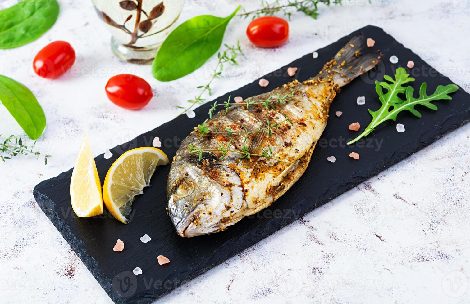 poisson dorado grillé sur fond blanc. poisson de mer rôti aux épices et herbes photo