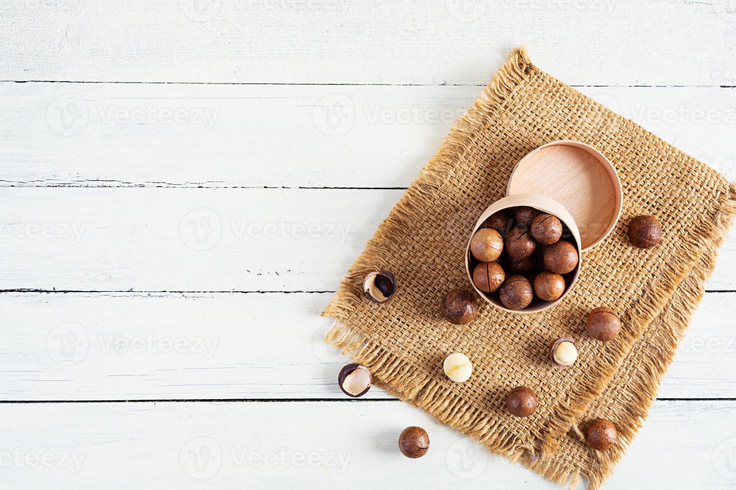 noix de macadamia en coquille sur fond en bois. vue de dessus photo