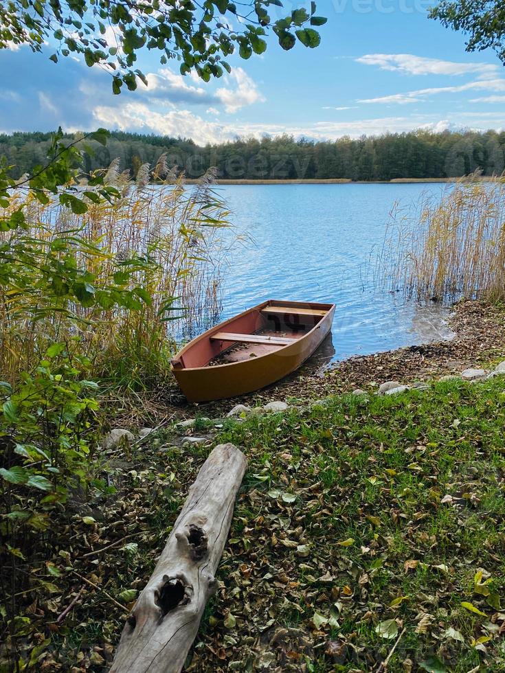 bateau sur la rive du lac d'automne photo