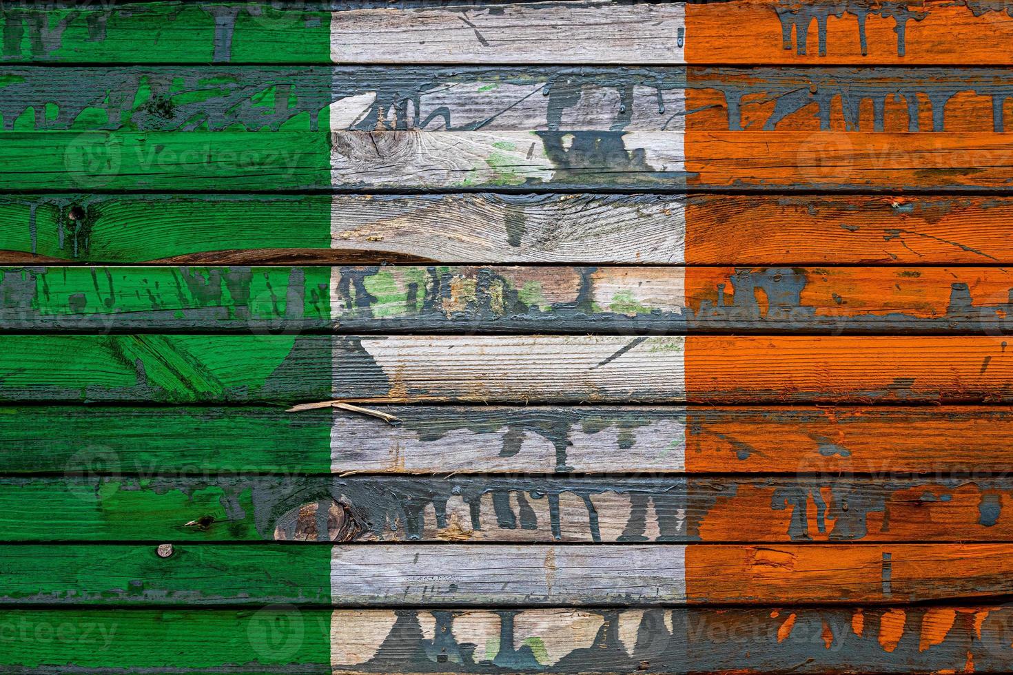 le drapeau national de l'irlande est peint sur des planches inégales. symbole du pays. photo