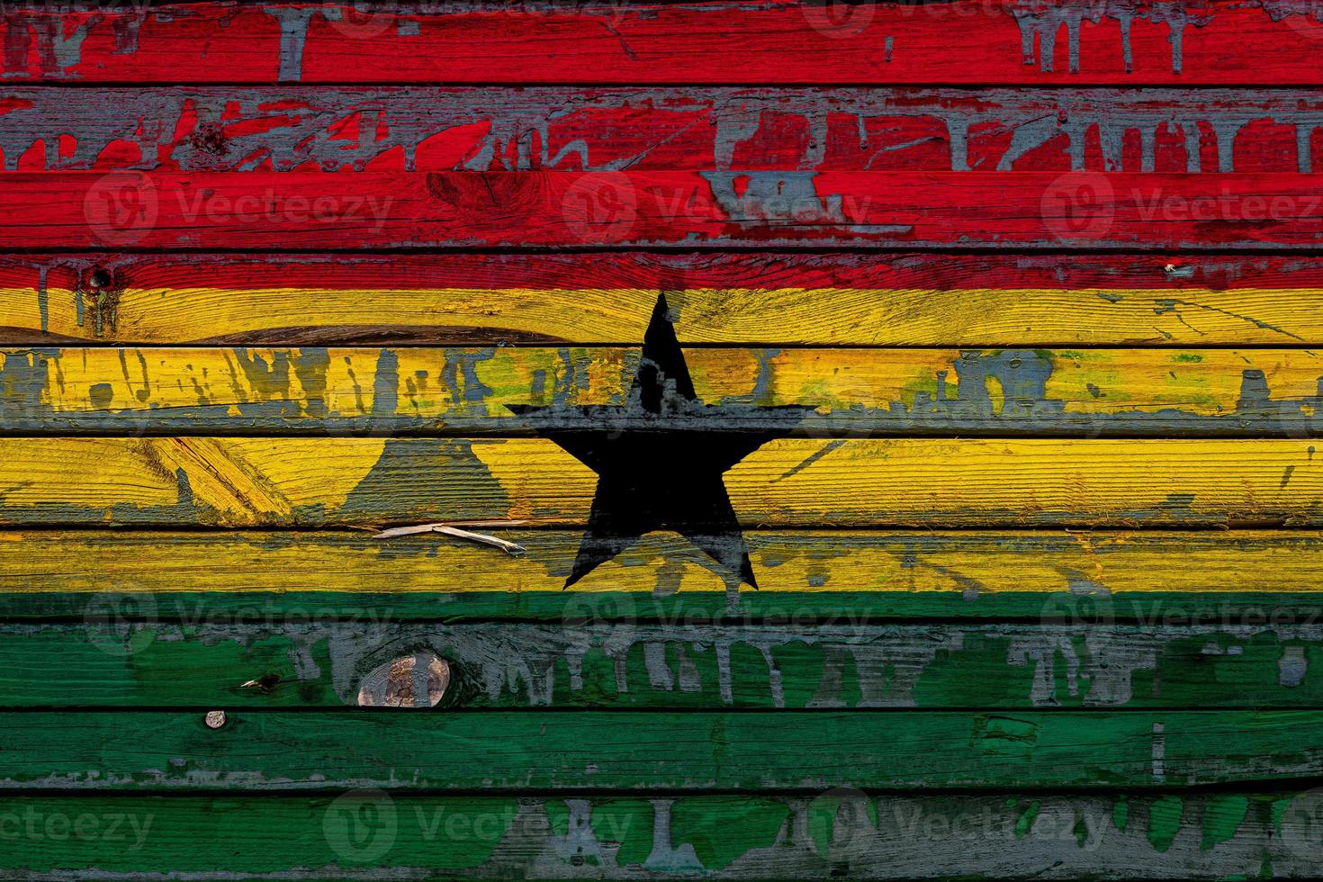 le drapeau national du ghana est peint sur des planches inégales. symbole du pays. photo