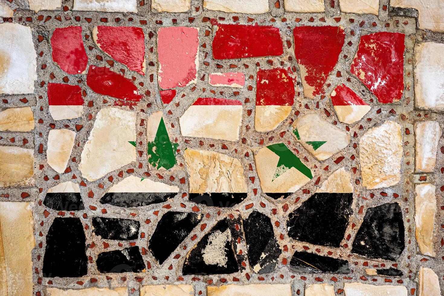 drapeau national de la syrie sur fond de mur de pierre. bannière de drapeau sur fond de texture de pierre. photo