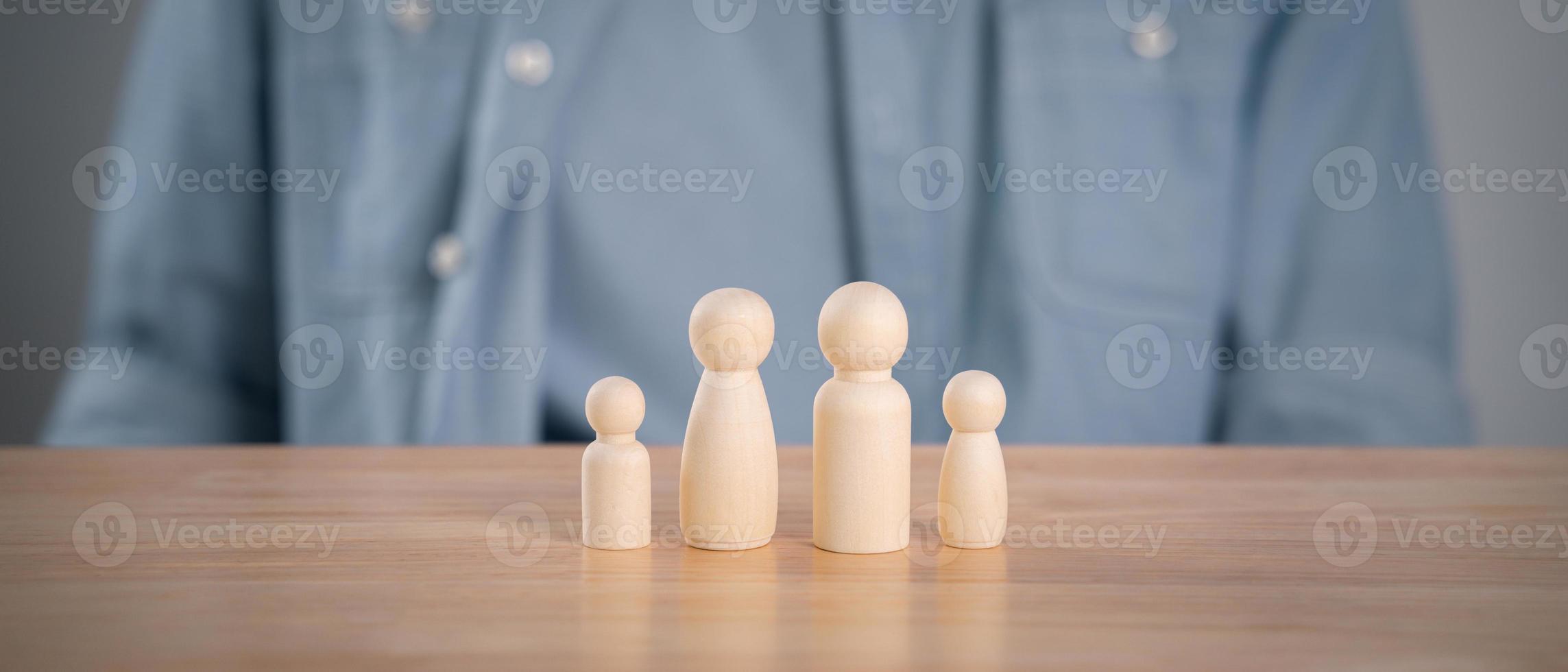 l'homme et les poupées en bois sur la table. planification, épargne familiale, soins de santé et assurance, santé mentale familiale, journée internationale des familles photo