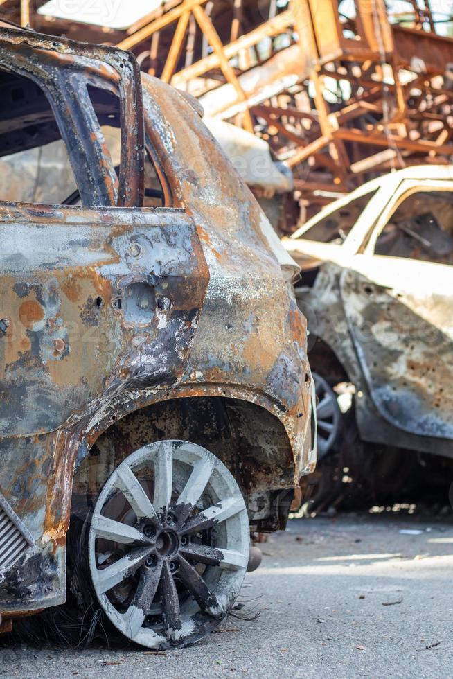 la voiture a brûlé complètement, même les pneus ont brûlé. accident de voiture brûlé après un incendie. l'obus de l'attentat terroriste a fait exploser des civils. zone sinistrée. voiture abandonnée sur la route. photo