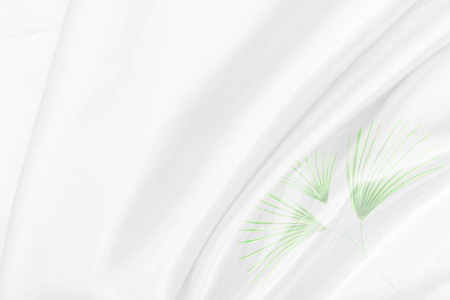 superposition de motifs de feuilles de palmier vert avec texture de tissu blanc arrière-plan flou doux photo