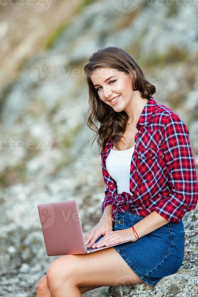 bureau à l'extérieur. belle fille travaille sur un ordinateur portable en plein air. femme indépendante. concept de travailleur indépendant. photo